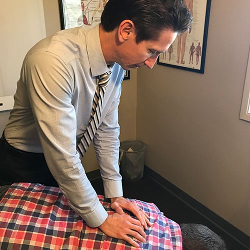 Chiropractor Carlsbad CA Jason Higgins Adjusting Patient